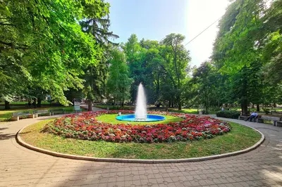 a fountain in the middle of a park with flowers at Maja Vujković Apartman 5 in Soko Banja