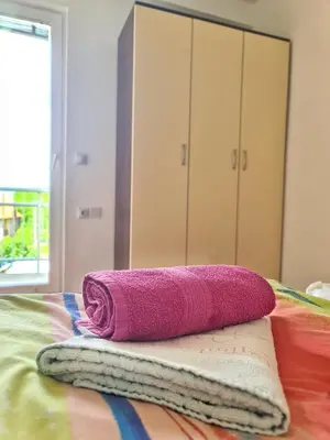 a pink towel sitting on top of a bed at Maja Vujković Apartman 5 in Soko Banja