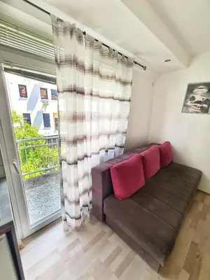 a living room with a couch and a window at Maja Vujković Apartman 5 in Soko Banja