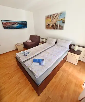 a bedroom with a bed and a chair in it at Maja Vujković Apartman 1 in Soko Banja