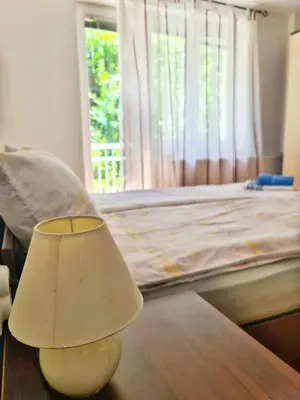 a lamp sitting on a table next to a bed at Maja Vujković Apartman 1 in Soko Banja
