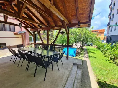 a patio with a table and chairs under a roof at Maja Vujković Apartman 1 in Soko Banja