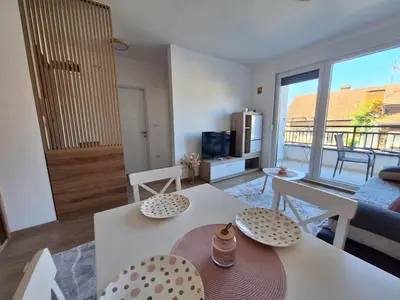 a living room with a white table and chairs at Apartman Šara in Vrnjačka Banja