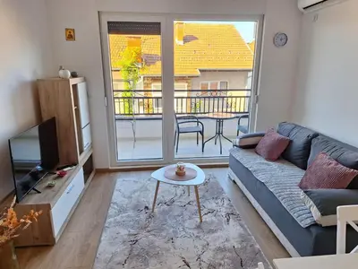 a living room with a couch and a balcony at Apartman Šara in Vrnjačka Banja
