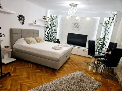 a bedroom with a bed and a flat screen tv at Deluxe Jade Apartmens in Niš