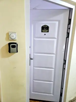 a white door with a sign on it at Deluxe Jade Apartmens in Niš