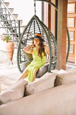a woman in a green dress sitting in a swing at Vila harmony in Trmčare