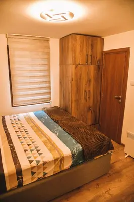a bedroom with a bed with a wooden cabinet at Vila harmony in Trmčare
