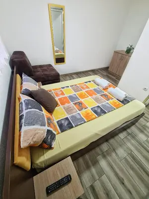 a bed with a quilt on it in a room at Vila Aleksandra 2 Apartman 1 in Soko Banja