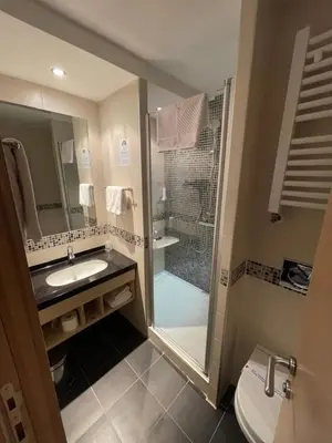 a bathroom with a shower and a sink and a toilet at Konaci Angella apartman 126 in Kopaonik