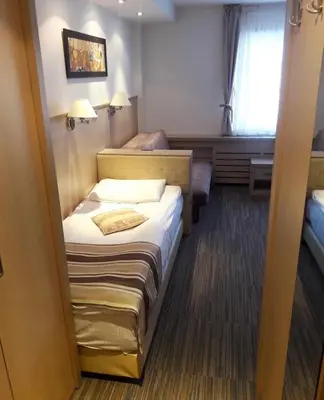 a small hotel room with a bed and a window at Konaci Angella apartman 126 in Kopaonik
