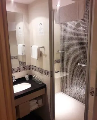 a bathroom with a shower and a sink and a shower at Konaci Angella apartman 126 in Kopaonik