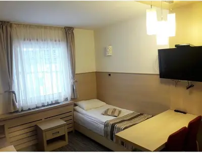 a small room with a bed and a window at Konaci Angella apartman 126 in Kopaonik