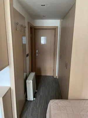 a room with a hallway with a door and a heater at Konaci Angella apartman 126 in Kopaonik