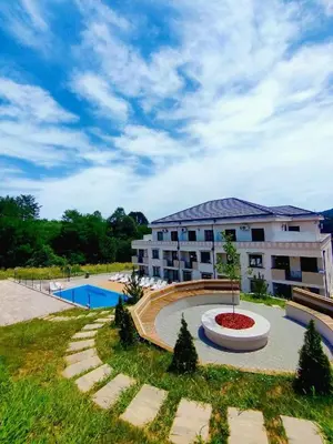 a large apartment building with a pool in front of it at Apartman Schwarzkopf in Vrnjačka Banja