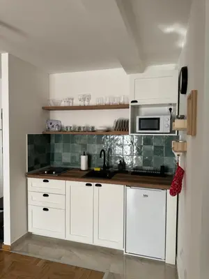 a kitchen with white cabinets and a microwave at Apartman Schwarzkopf in Vrnjačka Banja