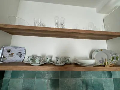 a shelf with dishes and glasses on it at Apartman Schwarzkopf in Vrnjačka Banja