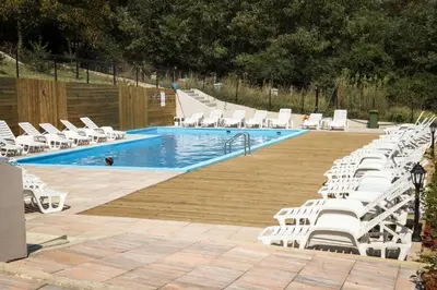 a swimming pool with white lounge chairs and a swimming pool at Apartman Schwarzkopf in Vrnjačka Banja