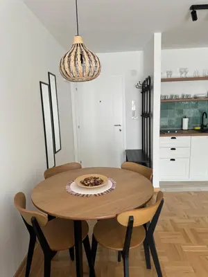 a dining room table with chairs and a chandelier at Apartman Schwarzkopf in Vrnjačka Banja