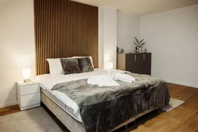 a bedroom with a large bed with a large window at Apartman Nina in Kopaonik