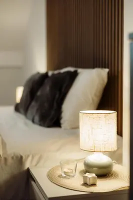 a lamp on a table next to a bed at Apartman Nina in Kopaonik