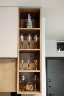 a wine cabinet with wine glasses and a christmas tree at Apartman Nina in Kopaonik