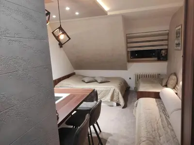 a small room with two beds and a table at Apartmani Iva Kop Konaci in Kopaonik