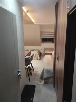 a room with two beds and a table with chairs at Apartmani Iva Kop Konaci in Kopaonik