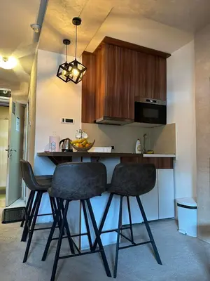 a kitchen with two bar stools and a counter at Apartmani Iva Kop Konaci in Kopaonik