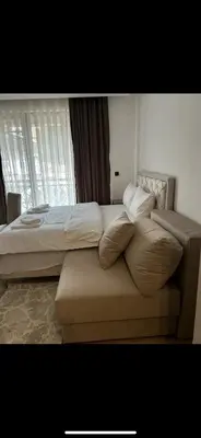 a bed with pillows and a couch in a bedroom at Nikola Residence Hill in Raška