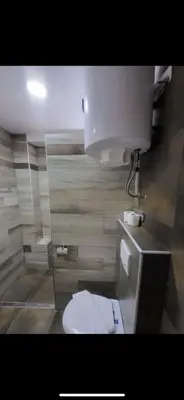 a bathroom with a white toilet in a room at Nikola Residence Hill in Raška