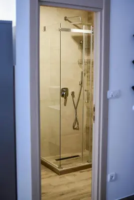 a shower with a glass door in a bathroom at Vila Montana, Kopaonik, Apartman Ivony in Kopaonik