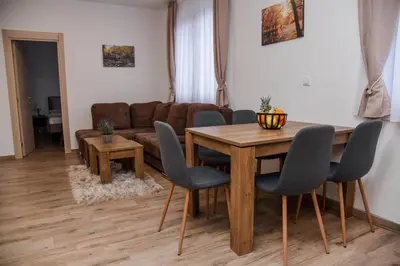 a living room with a table and a couch at Vila Montana, Kopaonik, Apartman Ivony in Kopaonik