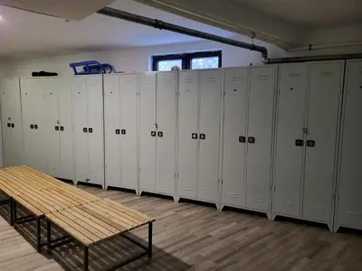 a row of white lockers in a room with a bench at Vila Montana, Kopaonik, Apartman Ivony in Kopaonik
