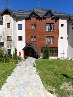 a large building with a stone path in front of it at Kopaonik - Milmari resort S66 in Kopaonik