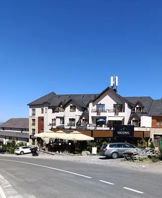 a large building with cars parked next to a street at Kopaonik - Milmari resort S66 in Kopaonik