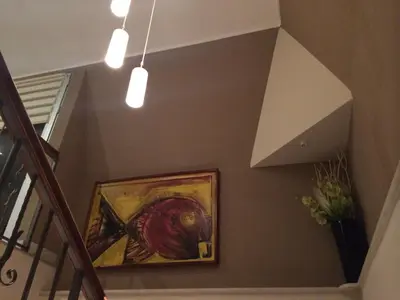 a staircase with a painting on the wall and lights at Prenociste Gazela in Pirot