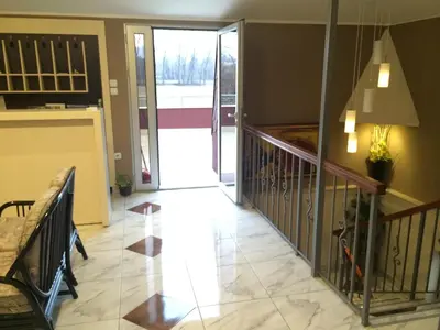 a living room with a staircase and a glass door at Prenociste Gazela in Pirot