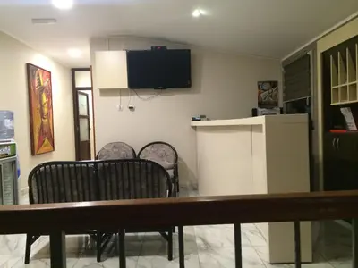a dining room with a table and chairs and a tv on the wall at Prenociste Gazela in Pirot