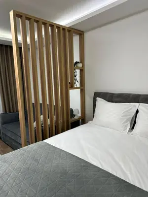 a bedroom with a large bed and a couch at Milanovic Apartman in Kopaonik