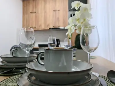 a table with plates and wine glasses on it at Milanovic Apartman in Kopaonik