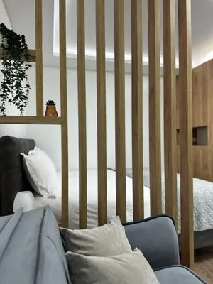 a room with a crib with a bed and a couch at Milanovic Apartman in Kopaonik