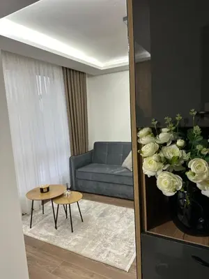 a living room with a couch and a vase of flowers at Milanovic Apartman in Kopaonik