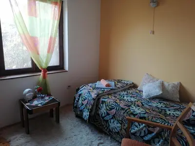 a bedroom with a bed and a table and a window at Vila Seoska idila in Izvor