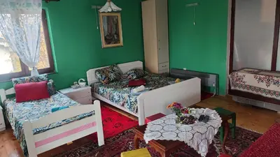 a room with two beds and a table and a bed and a table sidx sidx at Vila Seoska idila in Izvor