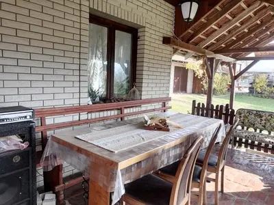 a wooden table with chairs on a patio at Vila Seoska idila in Izvor
