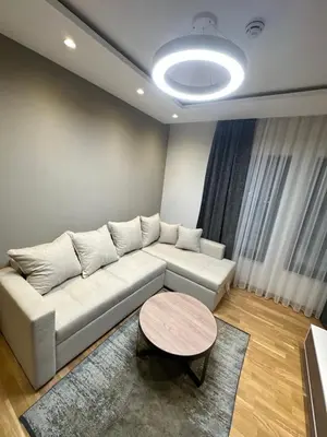 a living room with a white couch and a table at Vila Golija VM Apartment in Kopaonik