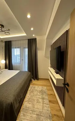 a bedroom with a bed and a flat screen tv at Vila Golija VM Apartment in Kopaonik