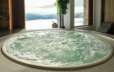 a jacuzzi tub in a room with a window at Vila Golija VM Apartment in Kopaonik