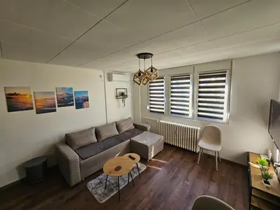 a living room with a couch and a table at Modern Apartment S22 in Niš